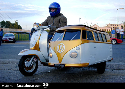 In Vespa con il sidecar a forma di pulmino della Volkswagen