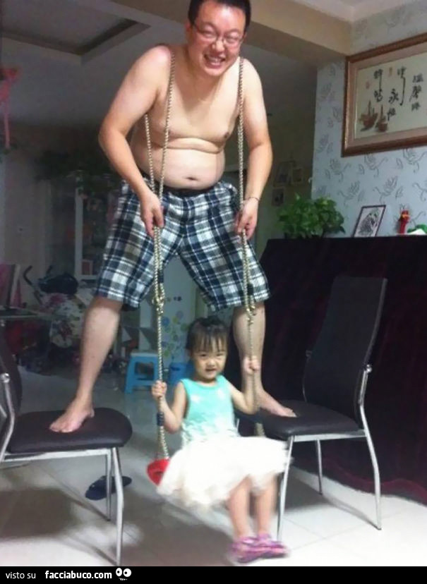 Padre dondola la figlia legando una corda sulle spalle e costruendo un'altalena