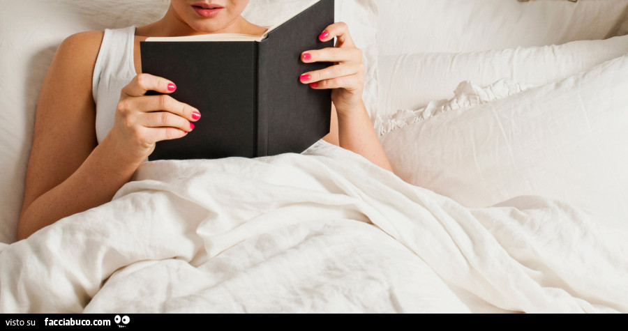 Donna a letto che legge libro